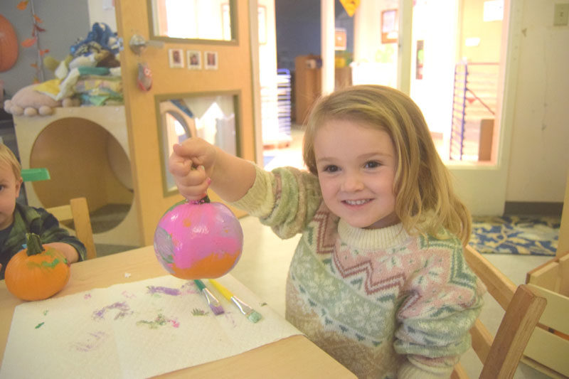 Luna Prock holds up her painted pumpkin during Coastal Kids Preschools sensory-friendly event on Monday, Oct. 13. The event centered around a visit from Carl the Collector, PBS Kids first lead character with autism, and featured other activities such as pumpkin painting, crafts, and a screening of the show. (Christina Wallace photo)