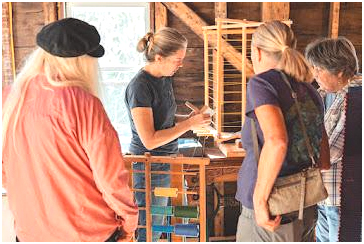 The Cultivated Thread owner Hilary Crowell demonstrates to visitors how to measure thread in the preparation process. Crowell, who has operated The Cultivated Thread, recently opened a storefront for the business on South Old Sheepscot Road in Wiscasset. (Photo courtesy Katie Kelley, The Cultivated Thread)