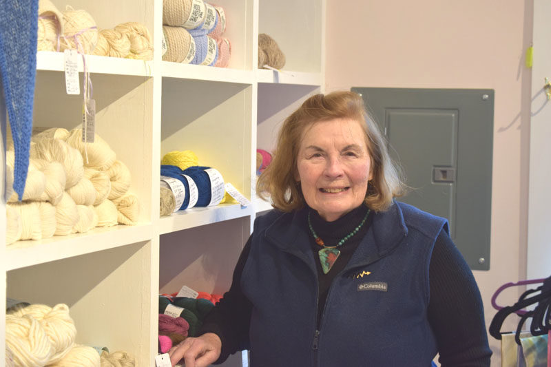 Kay Wegner, owner of Hillcrest House Fiber & Yarn in South Bristol, stands in front of shelves of yarn in her store on Monday, Nov. 17. Wegner has curated a collection of yarn from local farmers and artisans, along with specialty yarn from around the world. (Christina Wallace photo)
