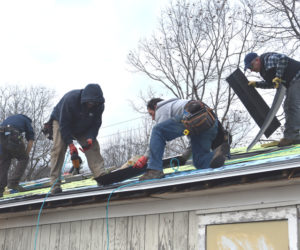RSU 40 Board of Directors member Timothy Wood, Scott Eastman and Garret Hayden, of Broad Cove Builders, and RSU 40 Superintendent Thomas Ambrose place new shingles on the roof of the seed bank building at Medomak Valley High School in Waldoboro on Friday, Nov. 21. Ambrose said he wanted the community to see that the administration at RSU 40 is willing to step up and do the work themselves to improve the facilities at MVHS. (Claire Taylor photo)