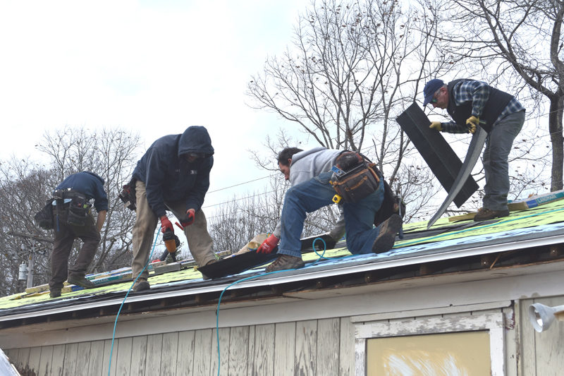 RSU 40 Board of Directors member Timothy Wood, Scott Eastman and Garret Hayden, of Broad Cove Builders, and RSU 40 Superintendent Thomas Ambrose place new shingles on the roof of the seed bank building at Medomak Valley High School in Waldoboro on Friday, Nov. 21. Ambrose said he wanted the community to see that the administration at RSU 40 is willing to step up and do the work themselves to improve the facilities at MVHS. (Claire Taylor photo)