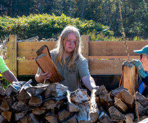 Bryse Thiboutot (center) stacks logs alongside Sarah Wills-Viega (left) and Linda Shaffer at the Bristol-South Bristol Transfer Station on Oct. 6. Thiboutot is one of a contingent of students from Lincoln Academys IDEAL Program, which provides regular off-campus opportunities for students to volunteer in high-engagement, individualized, and smaller-group learning environments. (Bisi Cameron Yee photo)