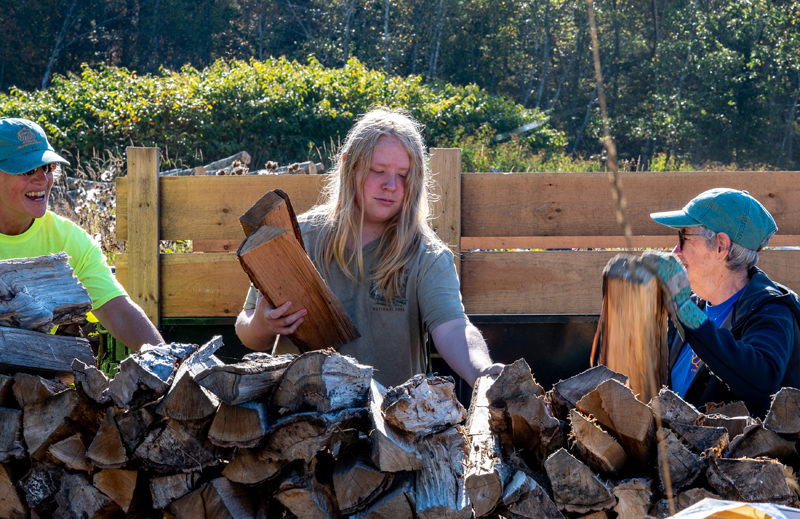 Bryse Thiboutot (center) stacks logs alongside Sarah Wills-Viega (left) and Linda Shaffer at the Bristol-South Bristol Transfer Station on Oct. 6. Thiboutot is one of a contingent of students from Lincoln Academys IDEAL Program, which provides regular off-campus opportunities for students to volunteer in high-engagement, individualized, and smaller-group learning environments. (Bisi Cameron Yee photo)
