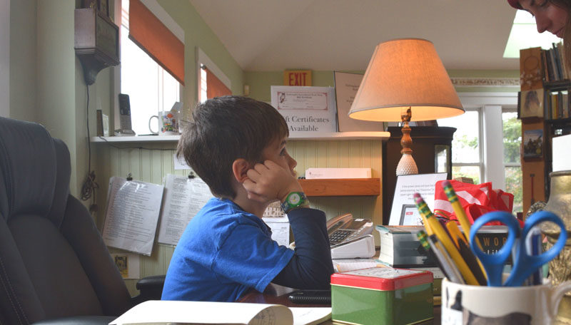 Harvey DeVoe, 8, mans the Skidompha Secondhand Book Shop's desk on Sunday, Nov. 16. DeVoe is the book shop's youngest volunteer, according to shop co-Manager Rosie Bensen. (Ali Juell photo)