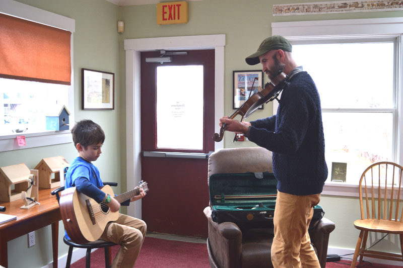 Harvey DeVoe (left) and his dad Bill DeVoe play for Skidompha Secondhand Book Shop patrons on Sunday, Nov. 16. Bill DeVoe said he and his son regularly volunteer at the book shop on Sundays. (Ali Juell photo)