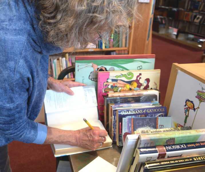 Skidompha Secondhand Book Shop co-Manager Rosie Bensen puts a price on a new children's book on Monday, Nov. 17. She said she is largely responsible for maintaining the store's section of childrens books. (Ali Juell photo)