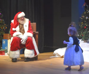 Two-year-old Hazel Woodard, of Damariscotta, runs across the Lincoln Theater stage to meet Santa Claus during his appearance on Saturday, Nov. 29. Santa's visit kicked off the day long Villages of Light Festival. Other festival events included a screening of the 2004 classic "The Polar Express," crafts the Skidompha Public Library, and the Villages of Lights parade. (Claire Taylor photo)