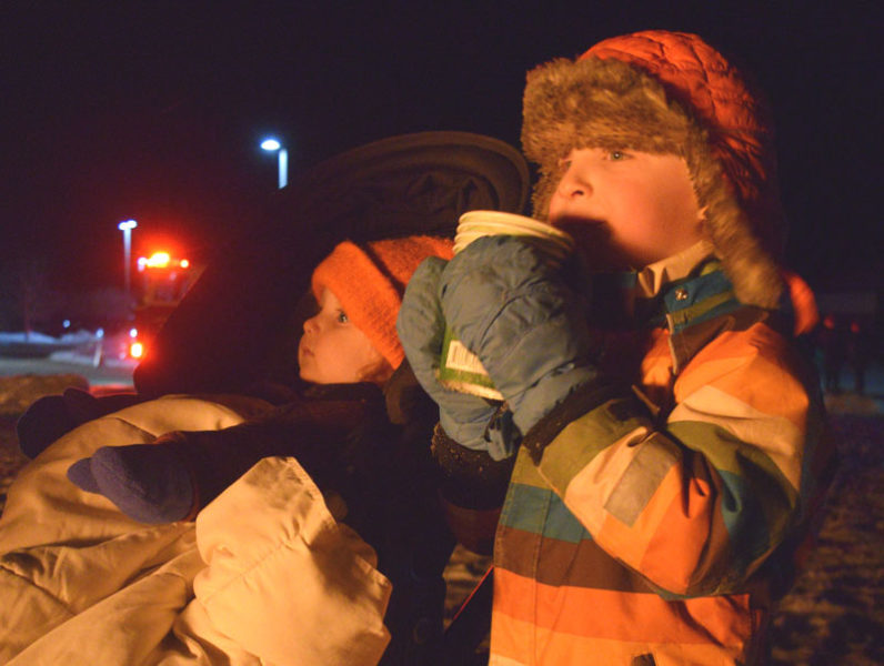 Toren Hammer (right), 5, enjoys some hot chocolate next to his little brother Aven Hammer, 1, in front of the bonfire at the Edgecomb Eddy School on Friday, Dec. 12. This was the second year the school hosted the Charlie Brown Christmas tree event. (Ali Juell photo)
