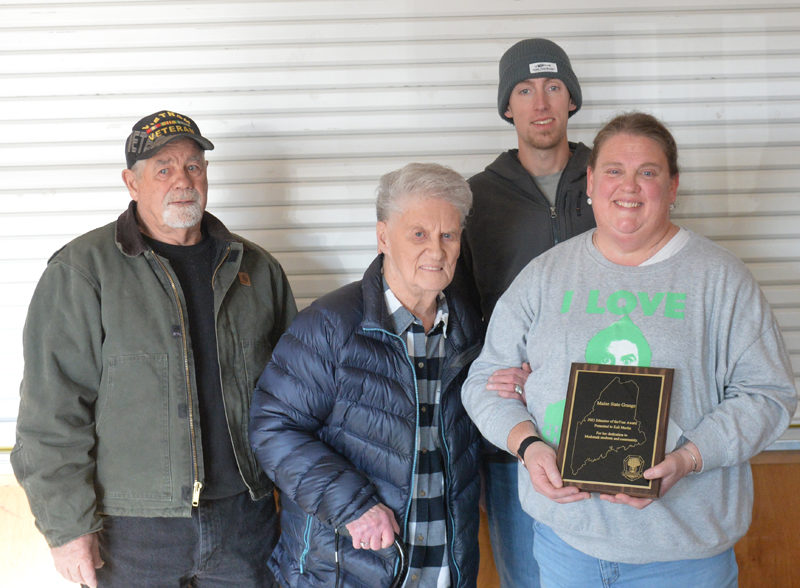Kali Martin holds her Maine State Grange Educator of the Year Award while surrounded by members of her family at Medomak Valley High School in Waldoboro on Monday, Dec. 22. From left: Bruce Poland, Bonnie Poland, Cameron Martin, and Kali Martin. (Paula Roberts photo)