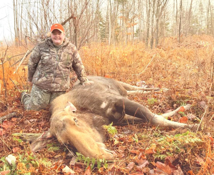 Helen Rice, 15, of Walpole, kneels next to the 585-pound cow moose she shot in October. (Courtesy photo)