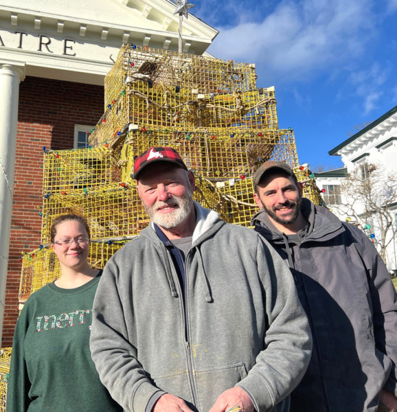 Volunteers (from left)  Sierra Poland, Clint Collamore, and Buddy Murray pause in front of the lobster trap tree they built in front of The Waldo Theatre Saturday, Nov. 29. (Photo courtesy The Waldo Theatre)