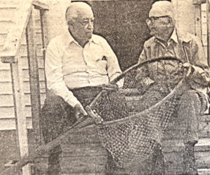 Nelson C. Hancock (left) and Harold Coombs share their alewife experiences during an open house at the Nobleboro Historical Center on Thursday afternoon, May 22, 1980. Hancock was a longtime operator of the alewife fisheries on behalf of the towns of Nobleboro and Newcastle. He developed and installed the mechanical hoists to replace the old method of hand dipping. Coombs was noted for his alewife smokehouse and the high quality of his smoked fish, which were sold throughout the coastal area. They are holding one of the old-time dip nets, used with much hand labor prior to 1955. (Photo courtesy Laurie McBurnie)
