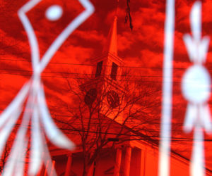 The Damariscotta Baptist Church as seen from across the street through a red glass window in the old firehouse. (Paula Roberts photo)