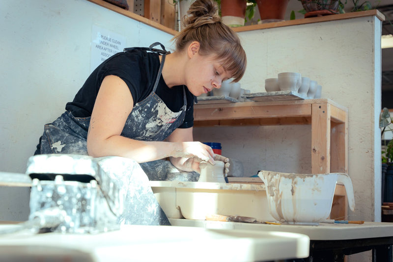 Aidan Fraser works on a piece for her Luster Hustler Ceramics business in her rented studio space in Portland in 2021. For Luster Hustler, Fraser specialized in producing human figurines that could double as a stand-alone sculpture or a functional item. (Photo courtesy Mailee Osten-Tan)