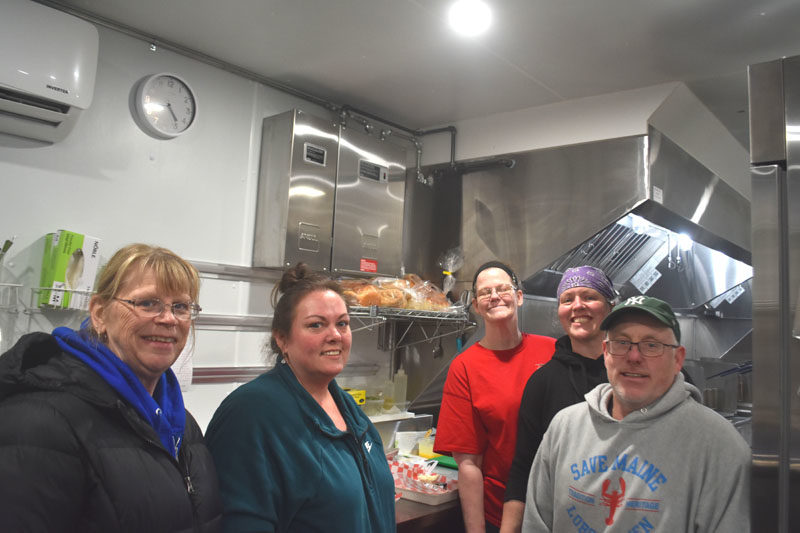 Kendall Delano Jr. and members of his kitchen crew are all smiles in the Delano Seafood Shack kitchen on Friday, Jan. 16. Prior moving into the newly constructed building, Delano and his crew ran the business from a 28-foot long trailer, year-round. From left: Angela Robinson, Crystal Wellman, Glendora Lash, Jessica Murphy, and Delano. (Claire Taylor photo)