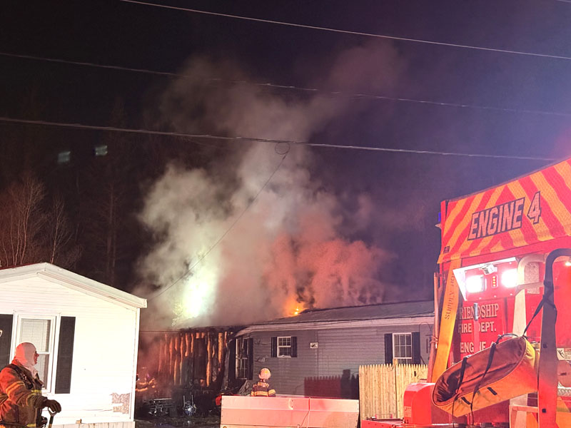 Smoke and flames rise from a mobile home in Waldoboro on Tuesday, Dec. 30. Firefighters from seven towns responded to the Brookside Mobile Home Park for a structure fire that destroyed a shed and part of a mobile home. (Christina Wallace photo)
