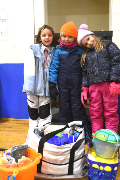Eleanor Wilkinson (left), 7, Cora Lynd (center), 7, and Sydney Olsen, 6, pose with the beach basket they won in a raffle during the WinterKids Family Night at Miller School in Waldoboro on Tuesday, Jan. 27. Funds from the raffle will support enrichment programs for students. (Claire Taylor photo)