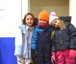 Eleanor Wilkinson (left), 7, Cora Lynd (center), 7, and Sydney Olsen, 6, pose with the beach basket they won in a raffle during the WinterKids Family Night at Miller School in Waldoboro on Tuesday, Jan. 27. Funds from the raffle will support enrichment programs for students. (Claire Taylor photo)
