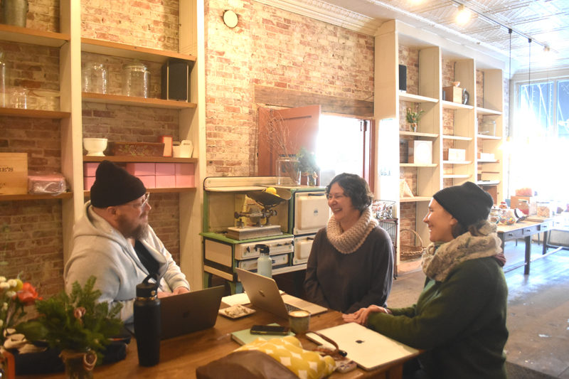 The past and present owners of Treats in Wiscasset share a laugh on Thursday, Jan. 8. Joseph Swifka (left) and Emily Hughes (center) recently purchased the cafe from Stacy Linehan and her husband, Ryan (not pictured), who have run the cafe for 20 years. (Claire Taylor photo)