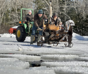 Thompson Ice House Preservation Corp. President Ken Lincoln (left) uses a tractor to help volunteers Andy Crockett (center) and Craig Manchester pull an antique gas-powered saw to cut through the ice at the annual ice harvest on Feb. 22, 2025. The annual event returns Sunday, Feb. 15. (LCN file)