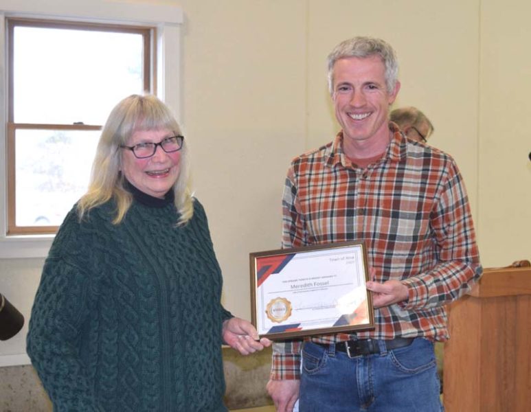 Alna First Selectperson Nick Johnston presents Mary Fossel with Alnas 2026 Spirit of America Award at the conclusion of Alnas annual town meeting on Saturday, March 21. Accepting the community service award, Fossel urged her fellow residents to get involved in their community. I keep volunteering, and I make a plug for everyone to volunteer, Fossel said. (Sherwood Olin photo)