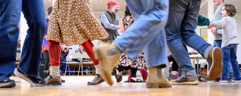 Andrew Donaldson (center) is framed by dancing feet at the Damariscotta Baptist Church on Jan. 9. Contra dancing in Maine goes back well over 100 years and is often based on traditional dances and folk music from the British Isles. (Bisi Cameron Yee photo)