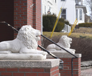 Two cement lions sit on pedestals outside of Skidompha Library in Damariscotta. The lions, named Curiosity and Perseverance, were installed in honor of the late executive director, Pam Gormley, who passed away in January. Gormley, a native of New York, wanted lions installed outside of Skidompha Library to match the lions outside of the New York Public Library. (Christina Brown photo)