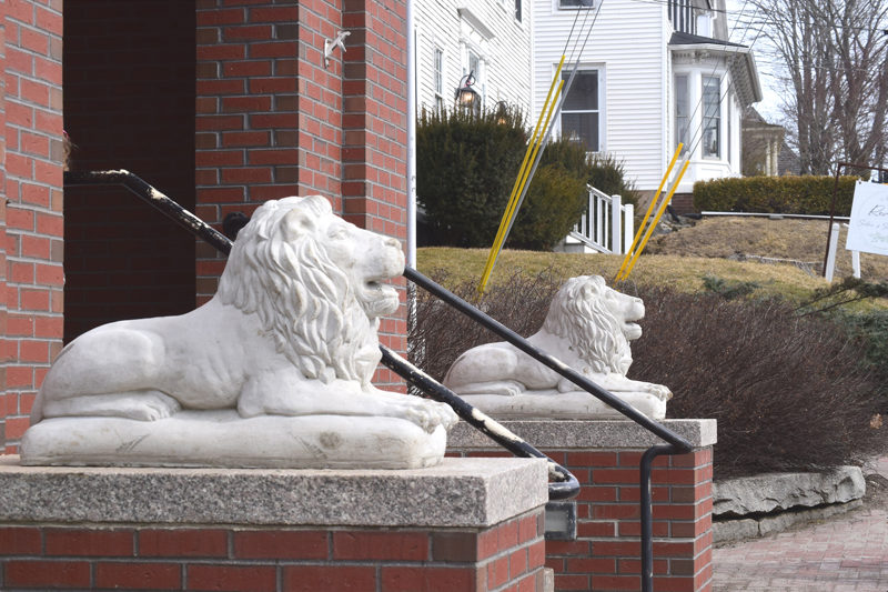 Two cement lions sit on pedestals outside of Skidompha Library in Damariscotta. The lions, named Curiosity and Perseverance, were installed in honor of the late executive director, Pam Gormley, who passed away in January. Gormley, a native of New York, wanted lions installed outside of Skidompha Library to match the lions outside of the New York Public Library. (Christina Brown photo)
