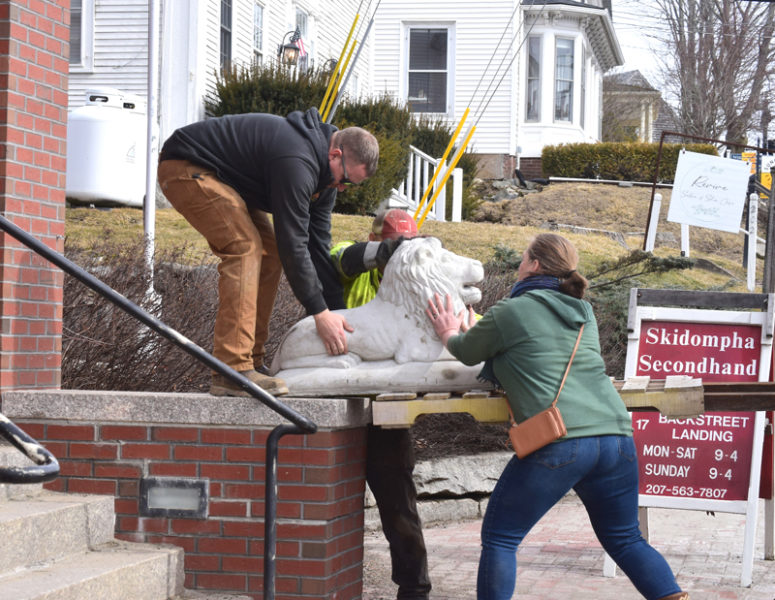 A cement lion is moved onto a pedestal outside of Skidompha Library in Damariscotta on Friday, March 13. The two lions that now sit outside the library were installed in memory of the former executive director, Pam Gormley, who passed away earlier this year. Hagar Enterprises, of Damariscotta, donated their time and equipment to assist in moving the lions. (Christina Brown photo)
