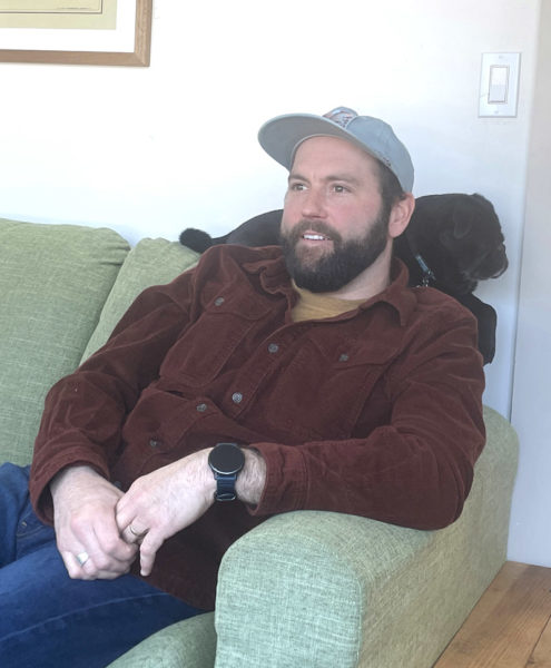 While the family dog Rudy provides neck support, Damariscotta contractor Ben Fearn discusses the meandering path he took on his way to becoming a a happily married family man and business owner. (Sherwood Olin photo)