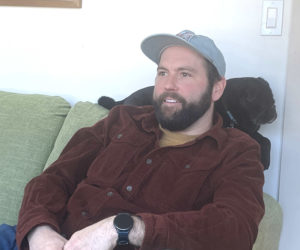 While the family dog Rudy provides neck support, Damariscotta contractor Ben Fearn discusses the meandering path he took on his way to becoming a a happily married family man and business owner. (Sherwood Olin photo)