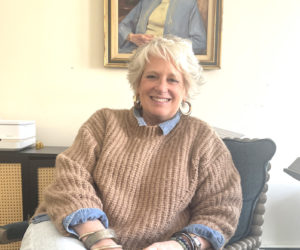 Lorrie Winslow, chief executive officer of The Lincoln Home, sits beneath a portrait of Lillian Albie Nash, one of the organizations founders, in her Newcastle office. A Waterboro native, Winslow knew little about the area before moving to Lincoln County with her husband in 2020. (Sherwood Olin photo)