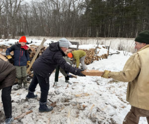 Community Housing Improvement Project Inc. volunteers lend a hand stacking fire wood for donation earlier this winter. The next community stacking day is Saturday, March 21. (Photo courtesy Community Housing Improvement Project Inc.)