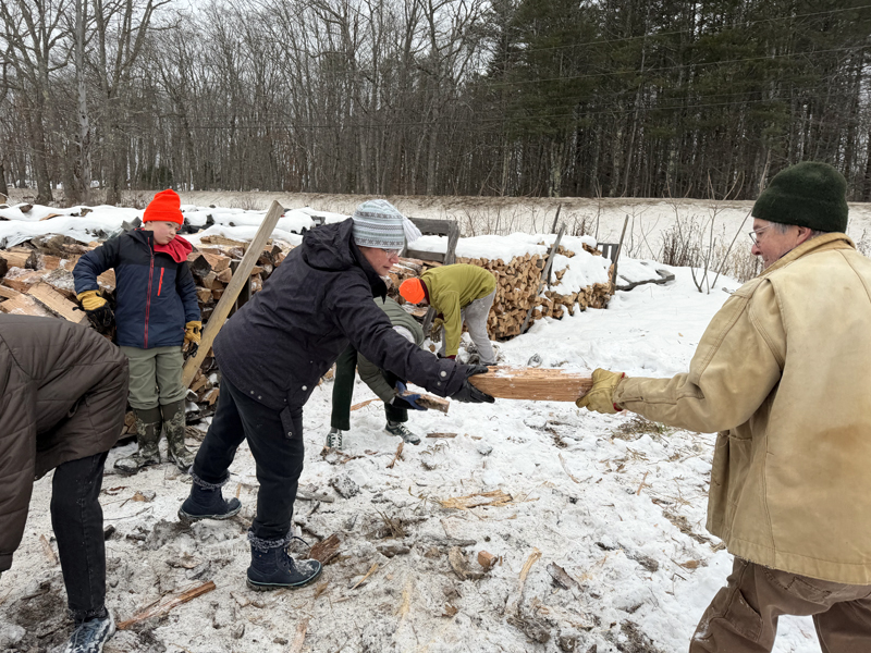 Community Housing Improvement Project Inc. volunteers lend a hand stacking fire wood for donation earlier this winter. The next community stacking day is Saturday, March 21. (Photo courtesy Community Housing Improvement Project Inc.)
