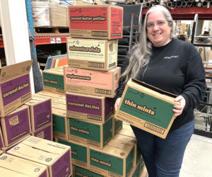 Angela White stands next to a stash of Girl Scout cookies at Homeport Supply in Newcastle. White first got involved with the Girl Scouts when her daughter Lucy took an interest. Fourteen years later, mother and daughter are both Lifetime Girl Scouts and Angela White said she has no plans to stop working with the organization. (Sherwood Olin photo)