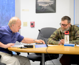Waldoboro Planning Board members Johnny Kosnow (left) and Shane McGarvey review plans for the construction and installation of a building and biomass boiler to replace the current heating system at Medomak Valley High School. The project was approved with several conditions. (Bisi Cameron Yee photo)