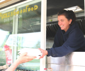 Mallory Heaberlin hands an order to a Truckin' Good Food customer. Heaberlin's truck is now in its second season at Louis Doe Home Center in Newcastle. (Christine Simmonds photo)