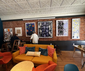 Carter Wentworth installs a displey at Perch Cafe and Bakery in preparation for the first Artwalk Waldoboro of the year. (Courtesy photo)