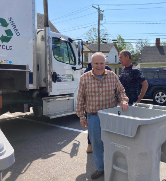 Volunteer Sarg Potter stands in front of the mobile shredding truck with a collection bin used for donated materials during a fundraiser benefiting the preservation of the Chapman-Hall House in Damariscotta. (Courtesy photo)