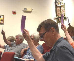 Damariscotta residents approve an article during the annual town meeting on Wednesday, June 10 at Skidompha Public Library. (Emily Bracher photo)