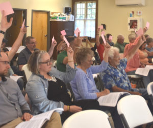 Dresden residents approve an article during the annual town meeting on Tuesday, June 16. Voters worked through the entire warrant in under an hour with limited discussion. (Emily Bracher photo)