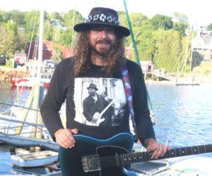 Ben Chute holds his guitar, Storytime, at Rockport Harbor after playing at the Donut Festival on Saturday, June 13. Chute has always had a passion for music, and has played since he was a child. (Christine Simmonds photo)