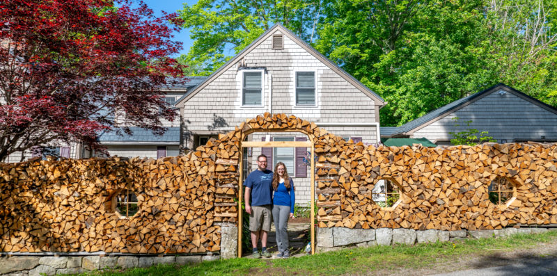 Will Fearn and Lauren Fowler stand in the arch that marks the entrance to their property in Damariscotta Mills on Wednesday, June 3. The couple built the surrounding wall out of the four cords of firewood that will be used to heat their home. (Bisi Cameron Yee photo)
