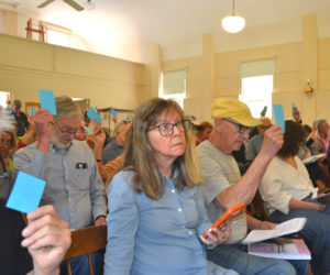 Westport Island voters raise their cards to approve an article at the annual town meeting on Saturday, June 20. (Charlotte Boynton photo)