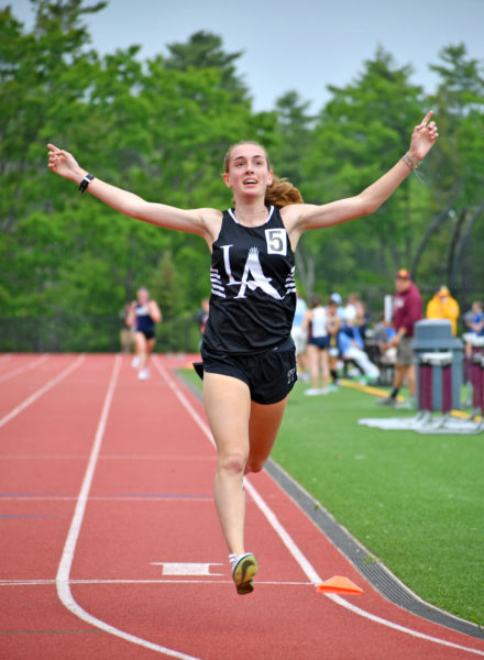 Lincoln Academy junior Karen Higgins celebrates as she crosses the finish line to win the Class B state championship in the 3200m run on Saturday, June 6 in Freeport. (Mic LeBel photo)
