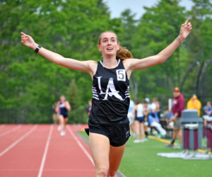 Lincoln Academy junior Karen Higgins celebrates as she crosses the finish line to win the Class B state championship in the 3200m run on Saturday, June 6 in Freeport. (Mic LeBel photo)