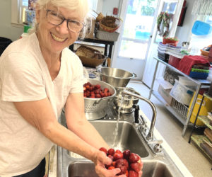 Pam Freeman, a longtime member of St. Philip's Episcopal Church and daughter of the founder of the Strawberry Festival, washes berries for shortcake. (Courtesy photo)