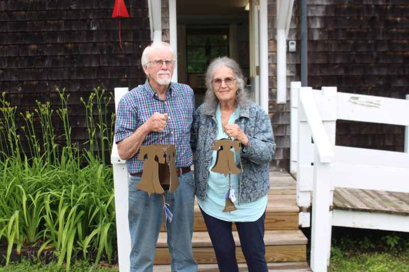 North Country Wind Bells owners Peggy and Ron Davis pose in front of the Waldoboro store with the liberty bell, which was created specifically to honor the 250th birthday of the USA. The liberty bell is available in two sizes and features a distinct tone that is deeper than the Buoy Bell. (Amelia Rice photo)
