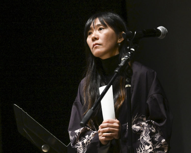Hanji Chang holds the letter she is about to read to her fellow storytellers At the Waldo Theatre in Waldoboro on June 6. Chang formatted her performance around a confessional letter to Puerto Rican singer Bad Bunny. (Bisi Cameron Yee photo)